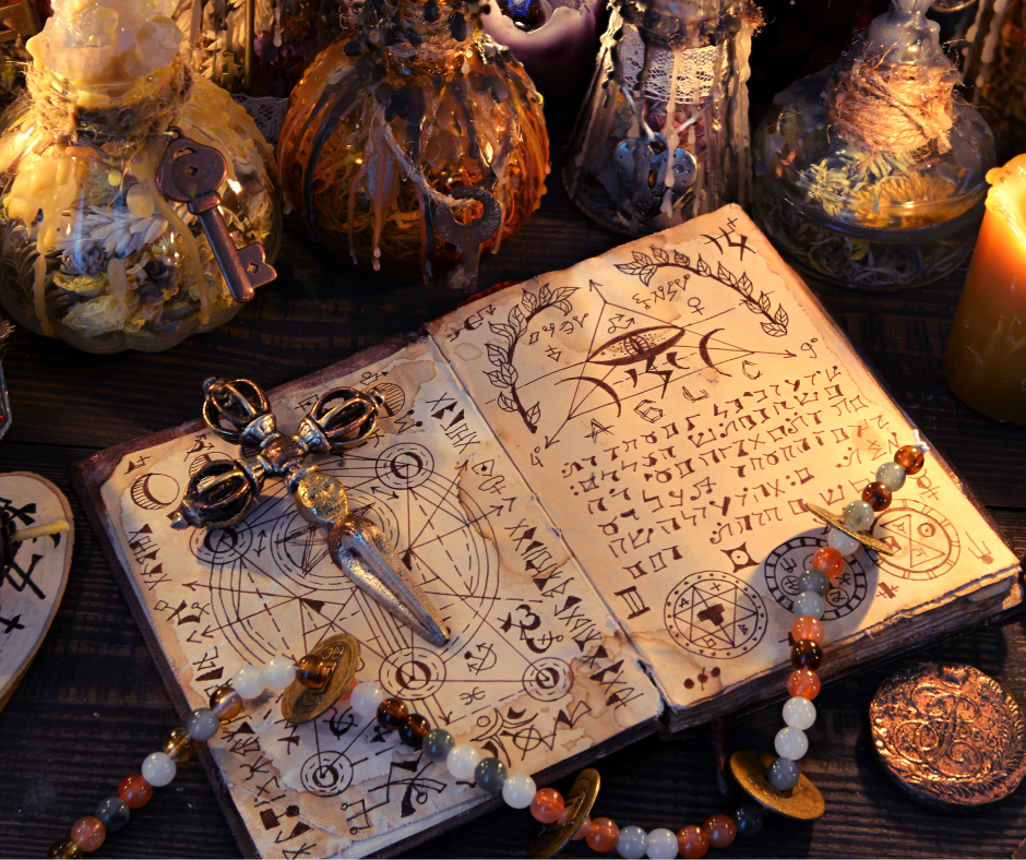History of our Order. Photo of a Book of Shadows with mystical writing, a small athame, gemstone beads, all in front of a many old bottles.